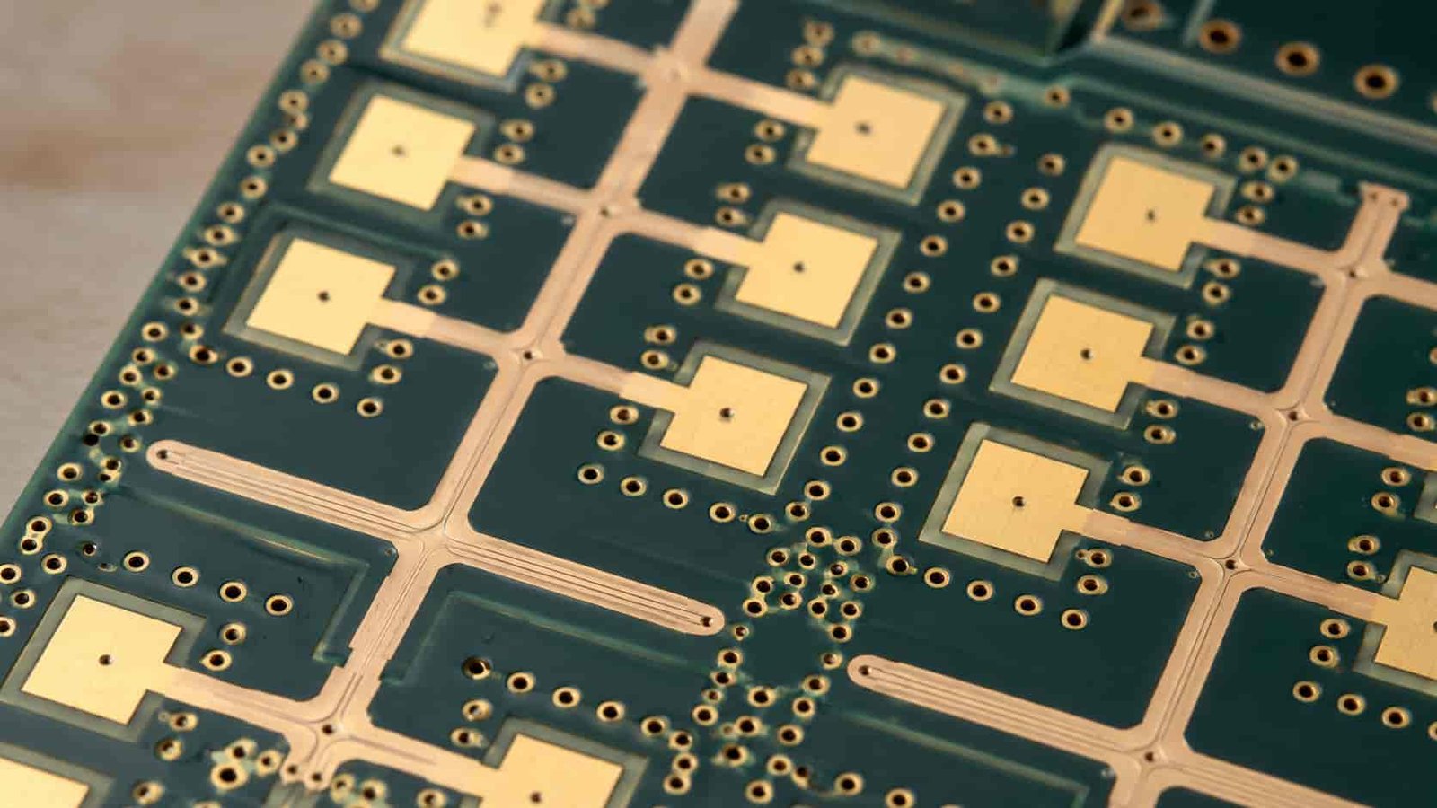 Phased array antenna PCB macro detail showing RF feed network repeated copper traces via fences gold pads and controlled impedance routing