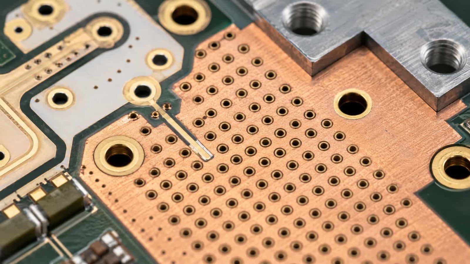 RF power amplifier PCB macro detail with thermal vias wide copper area plated holes RF trace transition and heat sink mounting area