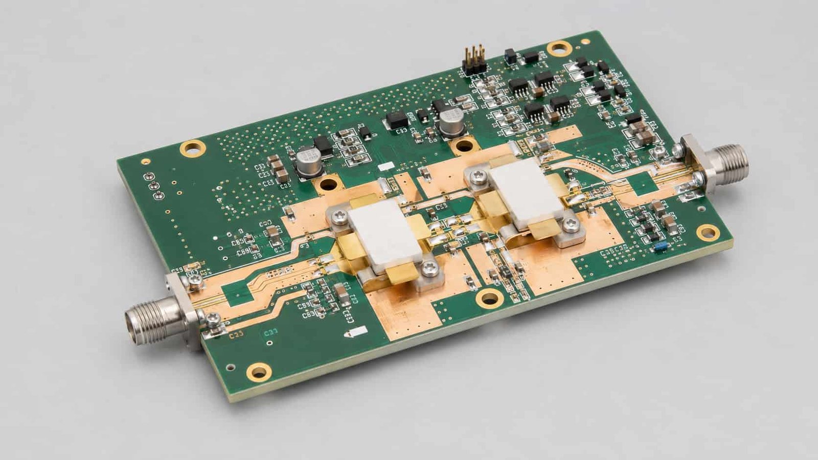RF power amplifier PCBA with RF connectors power transistors matching components wide copper areas plated vias and mounting holes