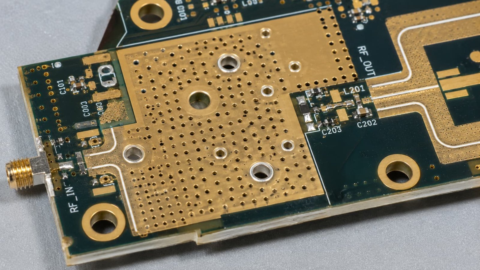Industrial RF PCB Thermal Via Detail Alt text: Industrial RF PCB macro detail with thermal vias wide copper RF trace plated holes gold pads and heat dissipation area